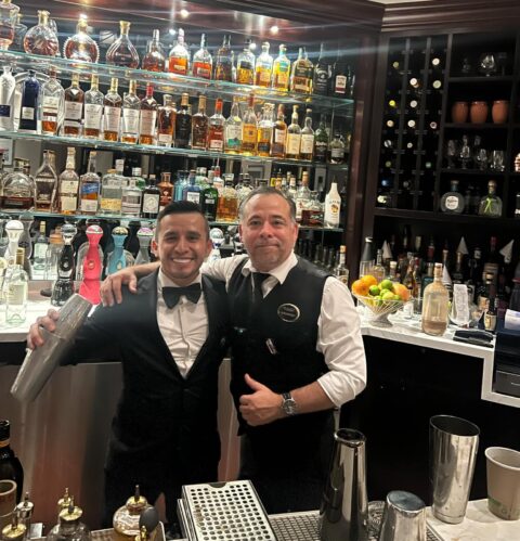 "Alam, barman en Aqualina Miami Beach y graduado de la Escuela de Coctelería 786 Bartend, mezclando cócteles en la barra de un reconocido establecimiento de 5 estrellas y un establecimiento animado."