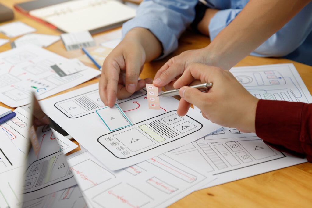 Importancia de la experiencia de usuario (UX) en el diseño web 3 Graphic designers work together with UX UI