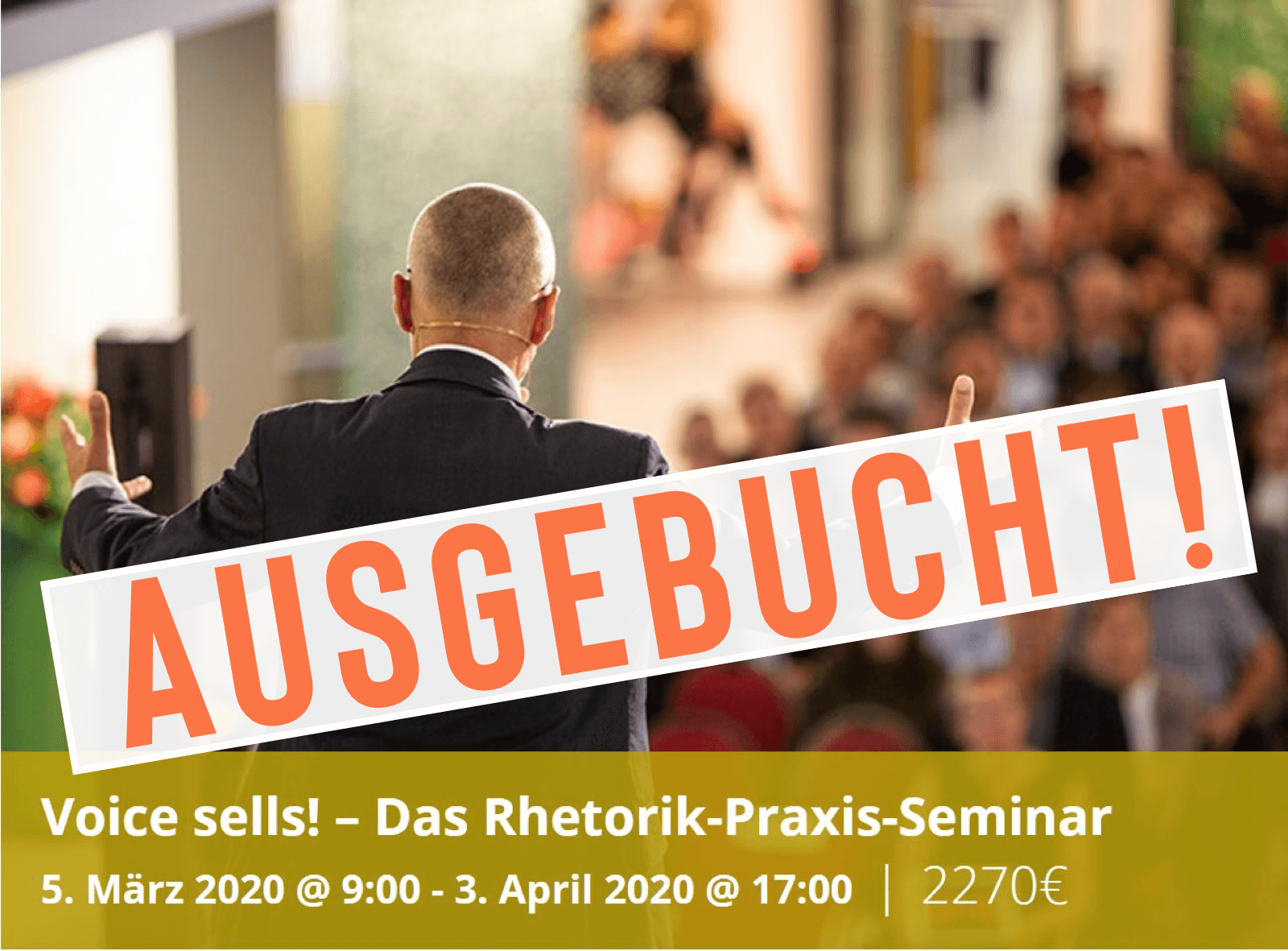 Un hombre de traje habla a una audiencia en un seminario. En la pancarta se lee: "¡La voz vende! – El Seminario de Práctica de Retórica" y "¡TOTALMENTE RESERVADO!", así como las fechas y horarios en marzo y abril de 2020.