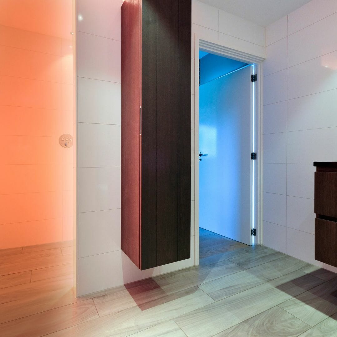 Badezimmer mit Holzboden, Akzentbeleuchtung und Wäscheschrank