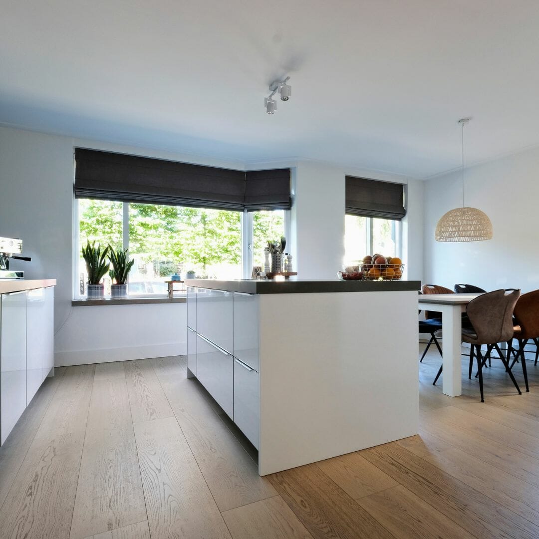 Offene Küche, geräumiges Design, Tageslicht, Holzboden, weiße Schränke, modernes Interieur, große Fenster, gemütliche Atmosphäre, Essbereich, stilvolle Einrichtung