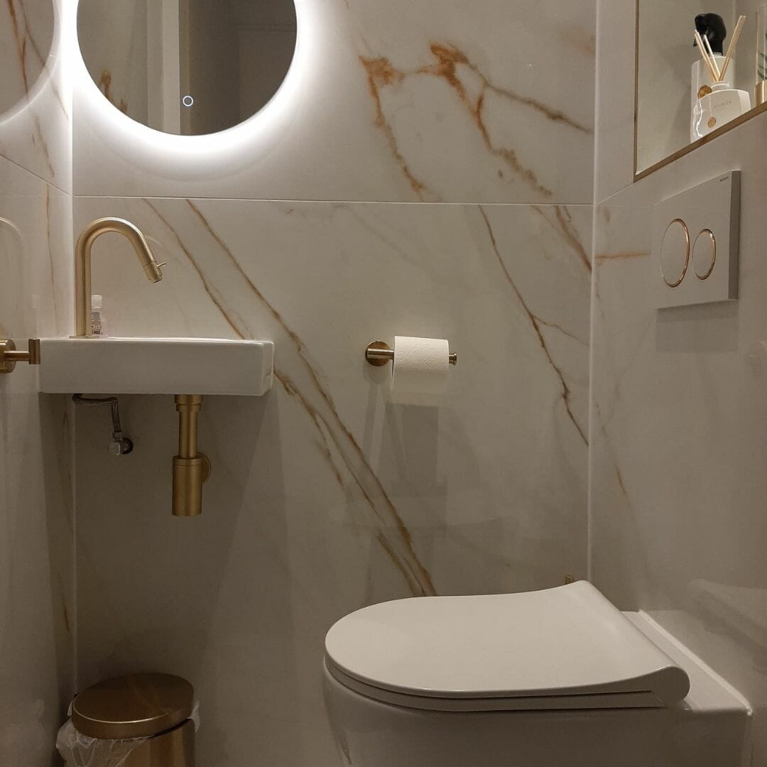 Kundenbeispiel für eine moderne Toilette mit Messing-Finish, neutrale Töne