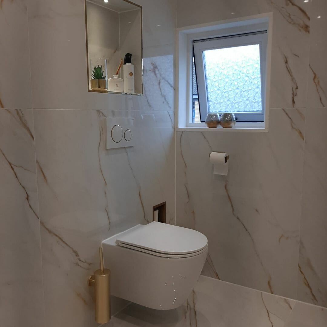 Kundenbeispiel für eine moderne Toilette mit Messingoberflächen, Marmordusche, goldenem Duschkopf, Luxusbad, eingebautem Regal, ästhetischem Design, reichen Texturen, modernen Armaturen, Wohnkomfort, stilvollem Interieur, Eleganz im Design