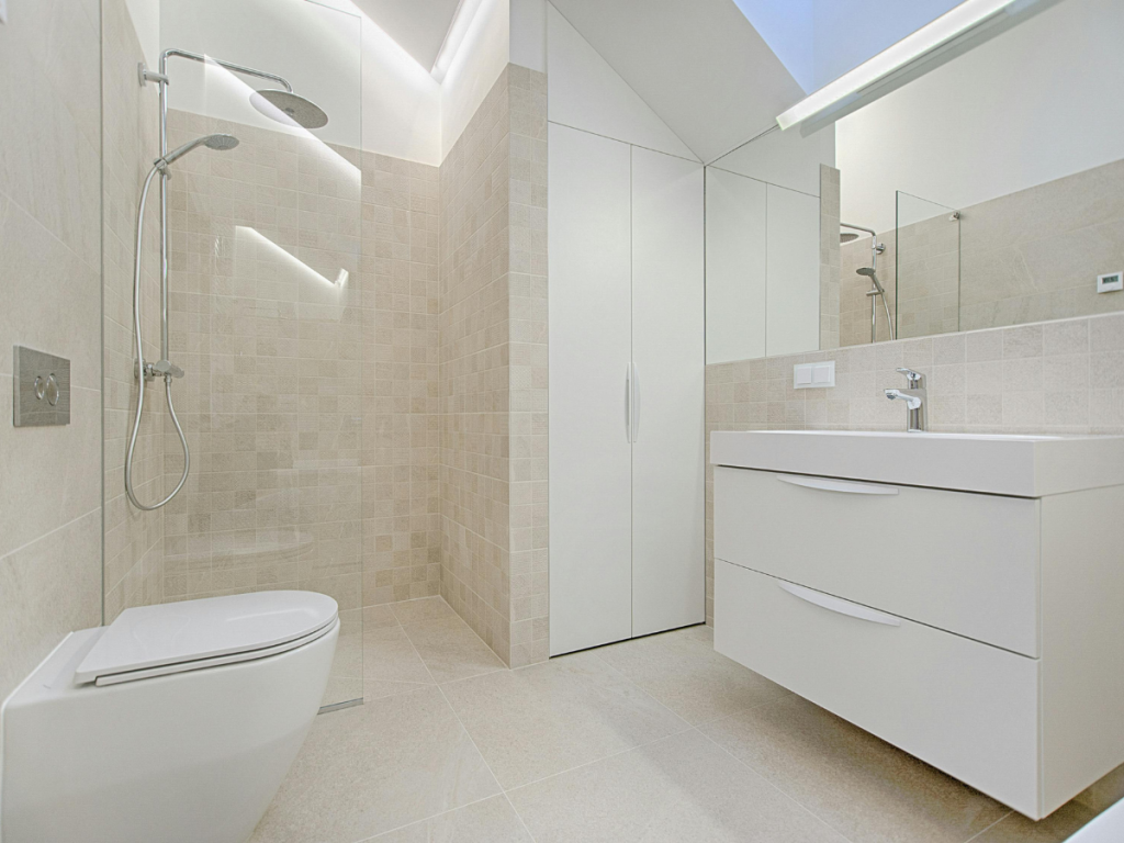 Modernes Badezimmer mit begehbarer Dusche, Wandschrank und weißem Waschbecken mit Waschbecken. Das geräumige Badezimmerdesign besteht aus hellbeigen Fliesen und einem großen Spiegel über dem Waschbecken, der zeitgenössischen Stil mit Funktionalität verbindet.