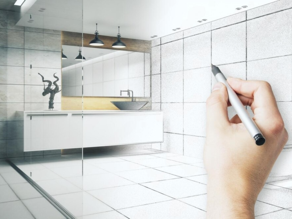Eine Hand zeichnet mit einem Stift ein Badezimmerdesign und geht nahtlos von der Skizze in die Realität über. Der Raum verfügt über ein Waschbecken, einen Wasserhahn, einen Wandspiegel, ein modernes Dekor unter Deckenleuchten und sogar einen Hauch von Küchengeräten für diejenigen, die innovative Details zu schätzen wissen.