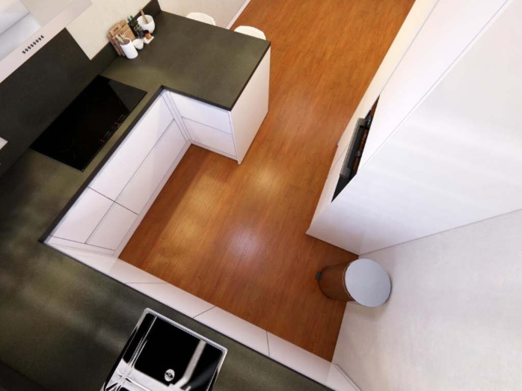 Draufsicht auf eine einladende Küche mit modernem U-förmigem Design mit schwarzen Arbeitsplatten, weißen Schränken, Herd, Spüle und Holzboden. Ein Mülleimer steht ordentlich in der Nähe der Wand.