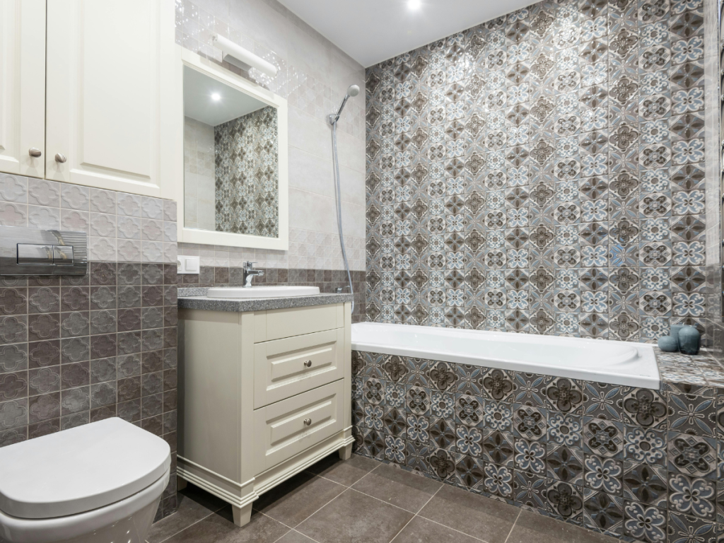 Modernes Badezimmer im eklektischen Stil mit karierten Fliesen, einer Badewanne mit Duschkopf, einem weißen Waschbecken mit Waschbecken und Spiegel und einer Toilette.