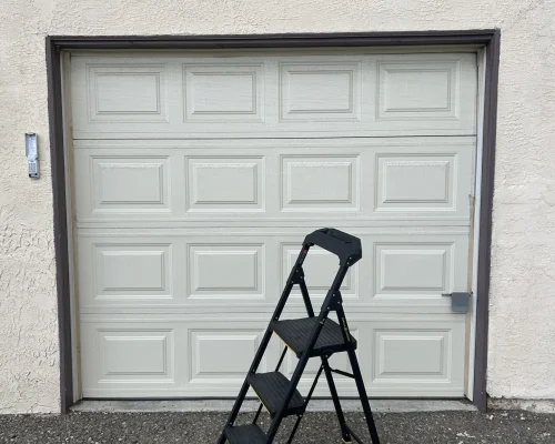 una escalera frente a la puerta de un garaje
