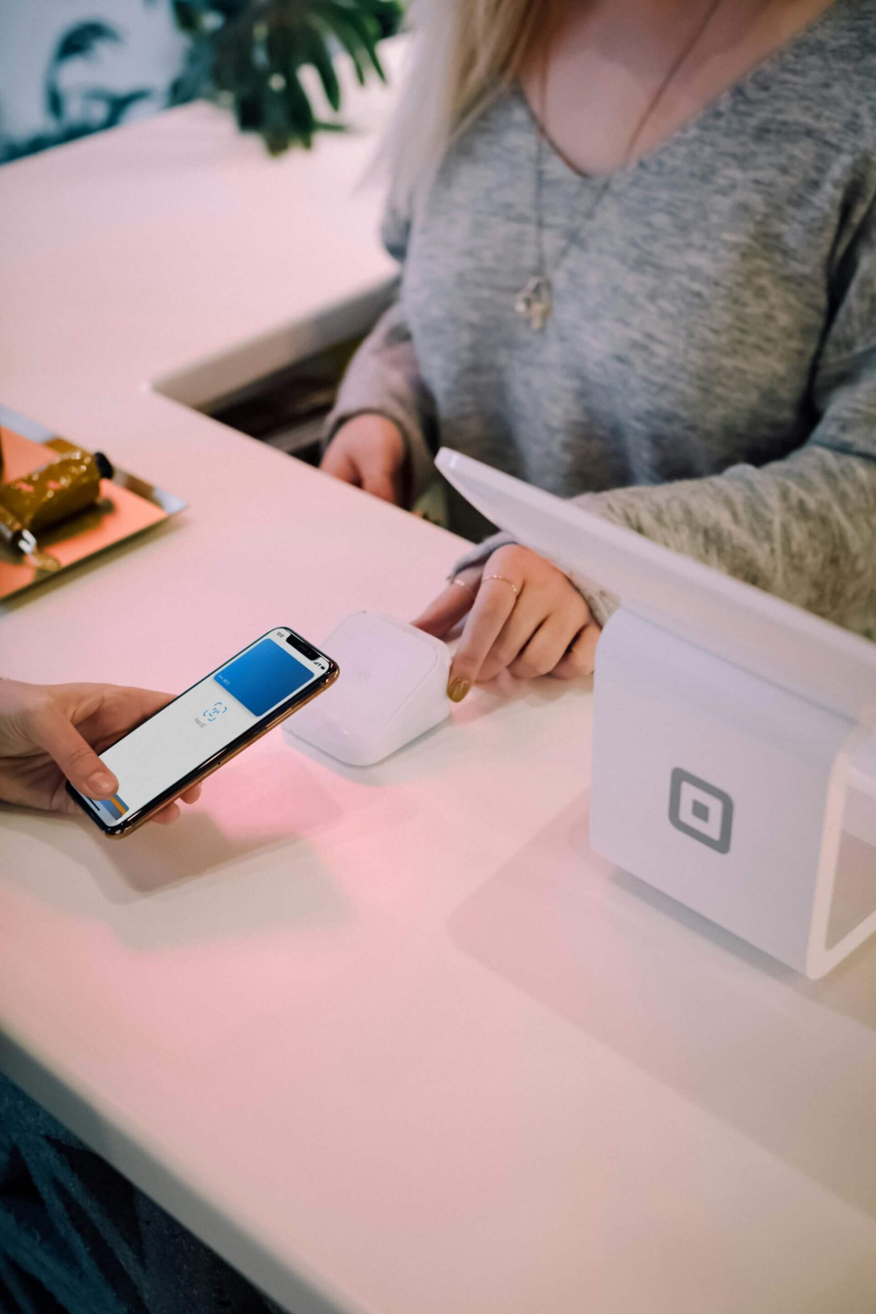 Import resale cross-border EC Customers make contactless payments using their smartphones at the white checkout counter in the store and are assisted by the staff.