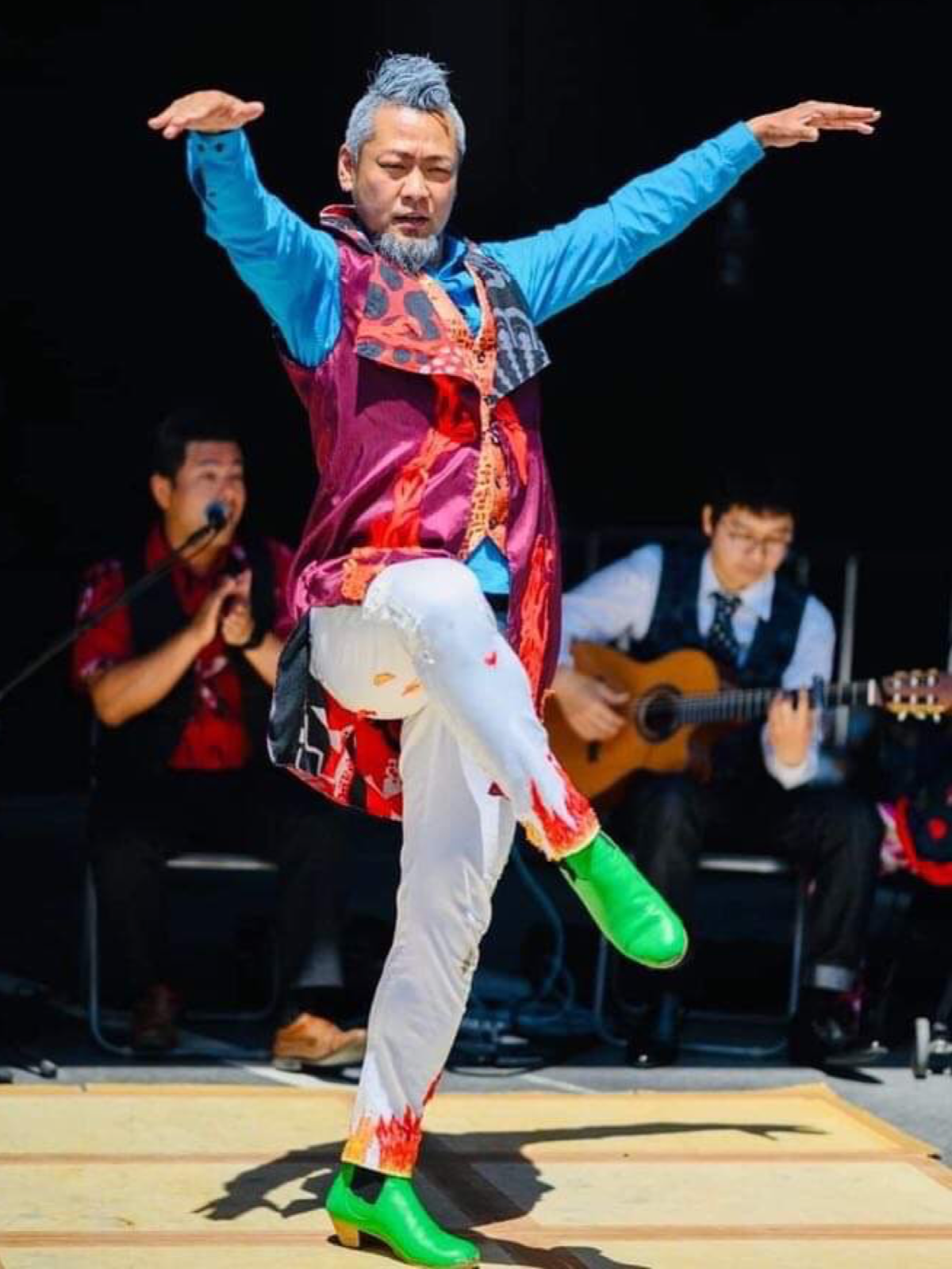 A man is dancing in front of a large crowd.