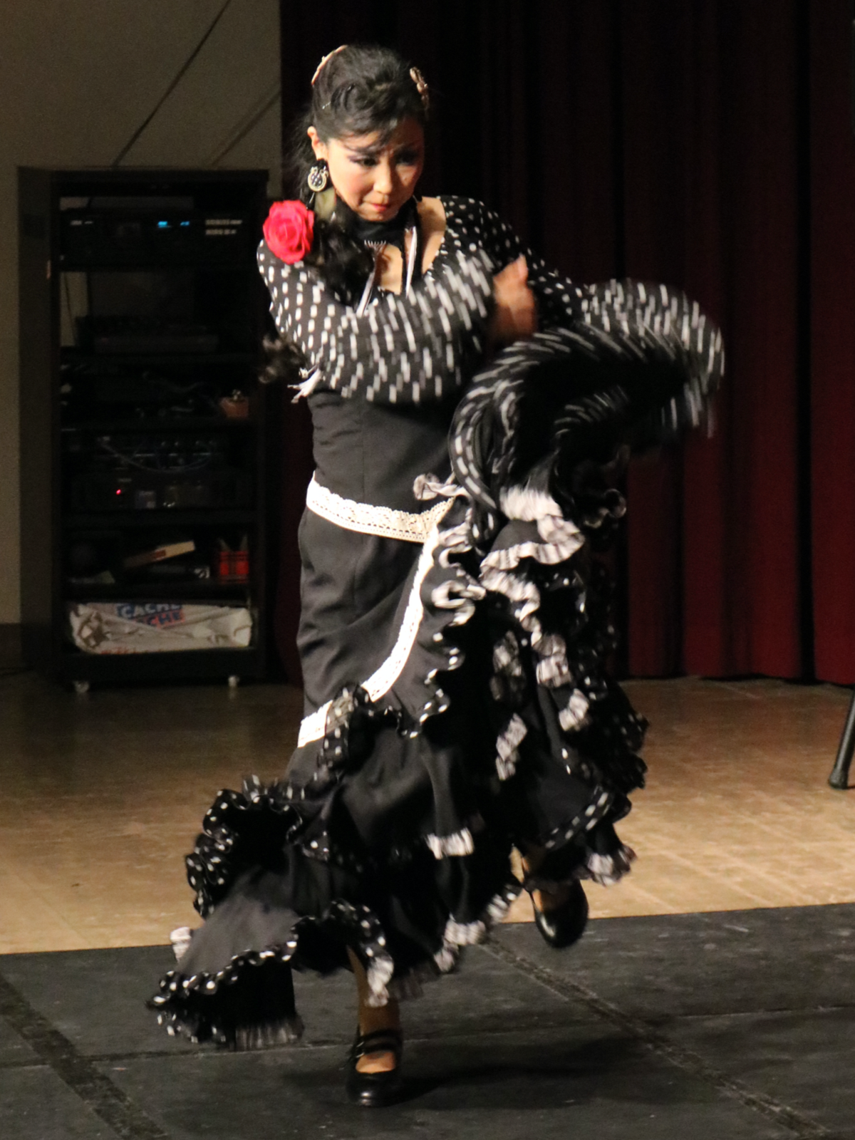 Woman dancing flamenco dance in black and white dress.