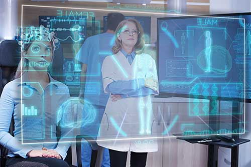 A group of people sit in front of a computer screen.