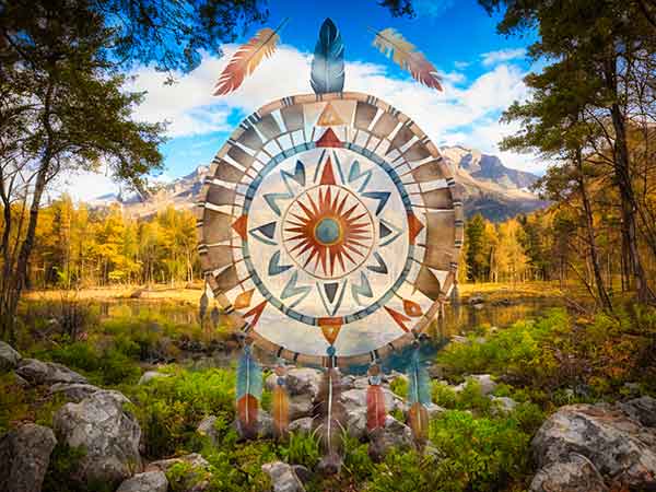 A dream catcher in front of a landscape.