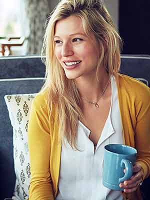 Eine Person, hält eine, trägt eine, lächelt und