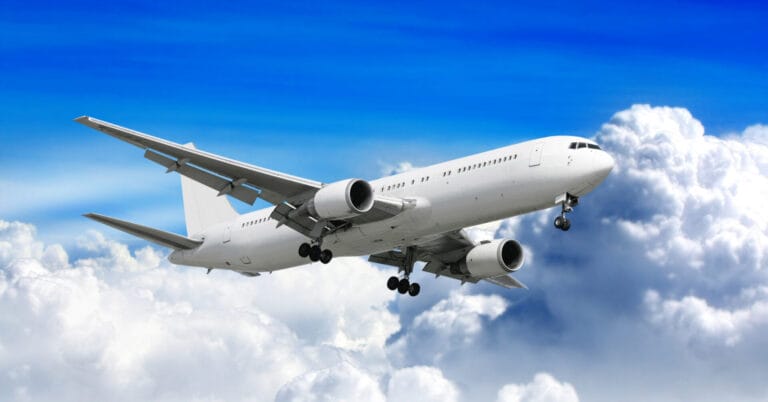 Puting pampasaherong eroplano na lumilipad sa itaas ng puting ulap na may malinaw na asul na kalangitan na nakapagpapaalaala sa mga paglipad ng Iligan.