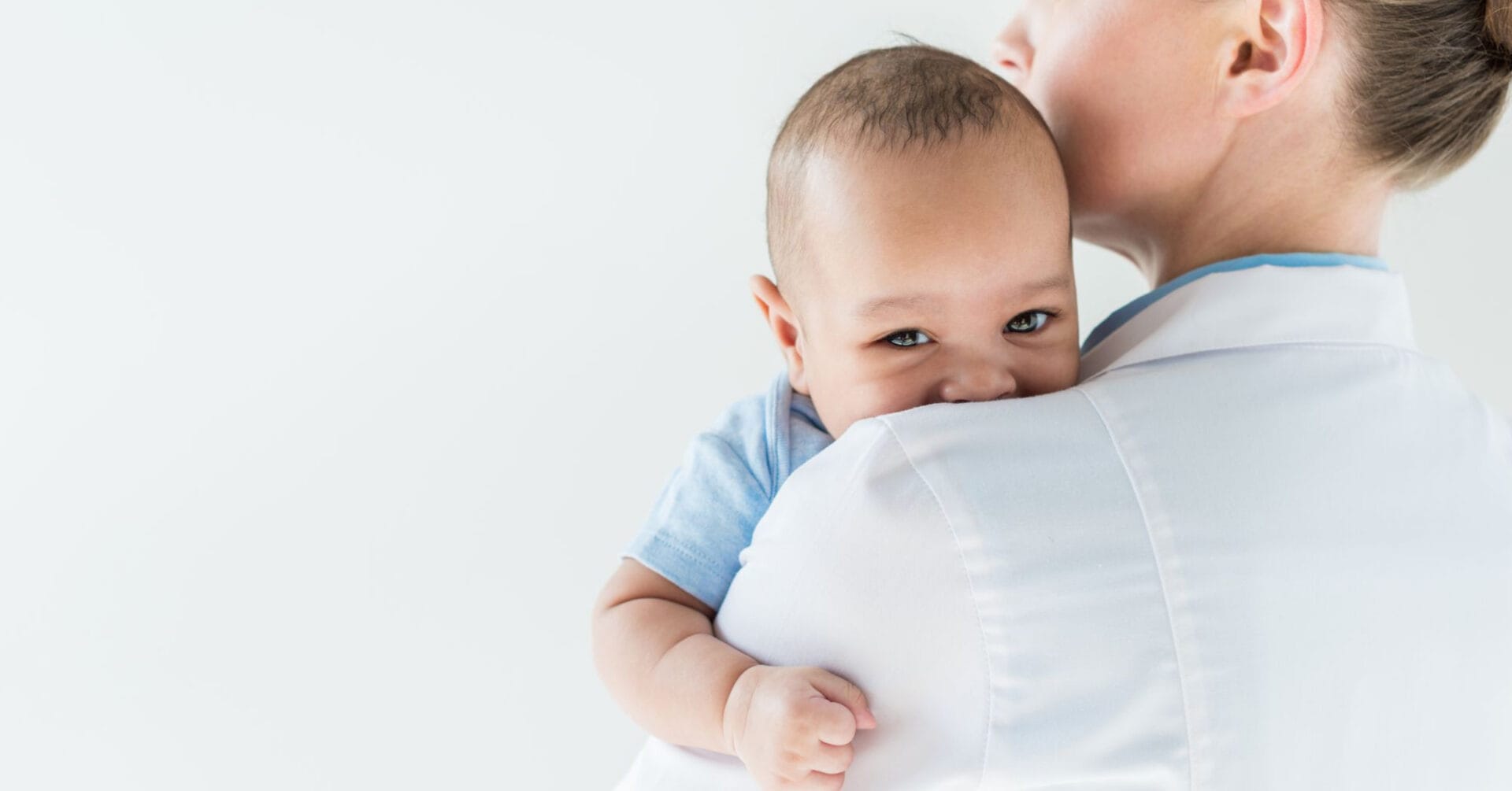 Matanda na may hawak na sanggol sa balikat, sanggol na nakatingin sa kamera, na nagpapaalala sa isang tahimik na sandali sa Pedia Iligan.