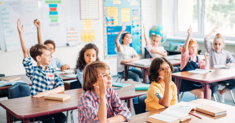 elementary students sit at desks in a bright classroom, inspired by unicef online courses to engage and learn.