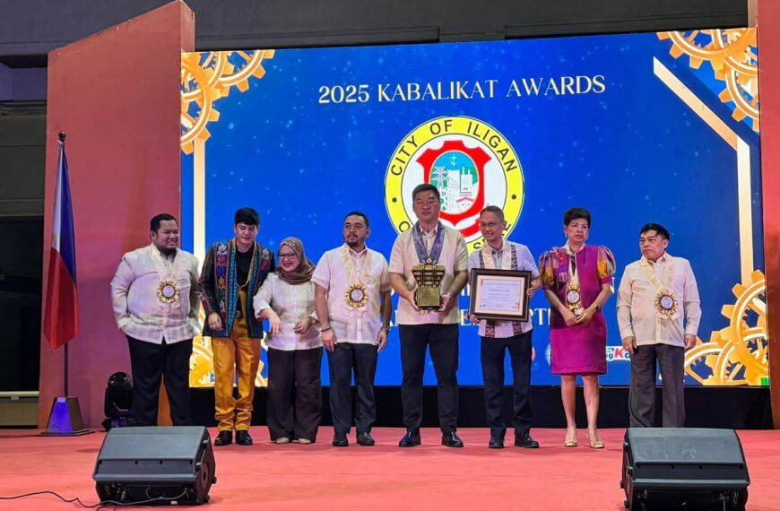 eight people in formal attire pose onstage with tesda kabalikat award trophies at iligan’s 2025 ceremony.