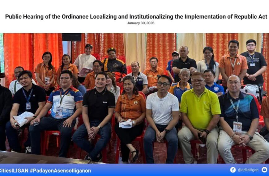 a group poses indoors at an iligan city public hearing on the ev ordinance, smiling and seated in rows.