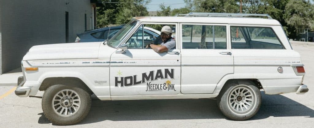 Logotipo de Holman Needle & Ink en un coche
