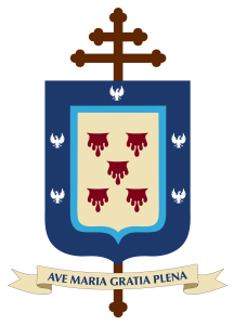 Escudo azul y crema con cinco gotas rojas y cuatro águilas blancas; doble cruz marrón en la parte superior. Lema: AVE MARIA GRATIA PLENA.