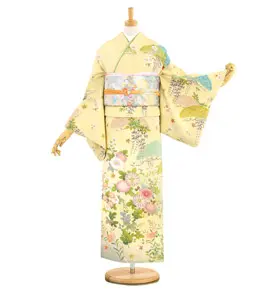 マネキンに飾られた着物。淡い黄色の地にパステルカラーの花や葉の模様が描かれています。腰には華やかな帯が締められ、装飾的な雰囲気を醸し出しています。.