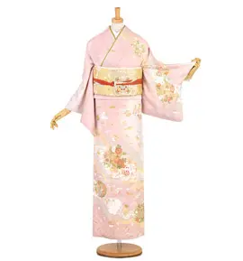 マネキンはピンクの花柄の着物とベージュの帯を身に着けています。着物には白、金、緑の繊細な模様が施され、帯には赤いアクセントが入っています。左袖は外側に長く伸びています。.