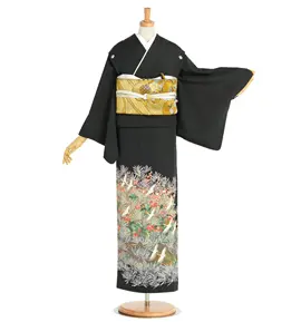 マネキンは、白い下地と精緻な金の帯を締めた黒い着物を着ています。着物の裾には、複数の色彩で繊細な花と鳥の模様が描かれています。片方の袖が上げられ、生地のドレープが美しく表現されています。.