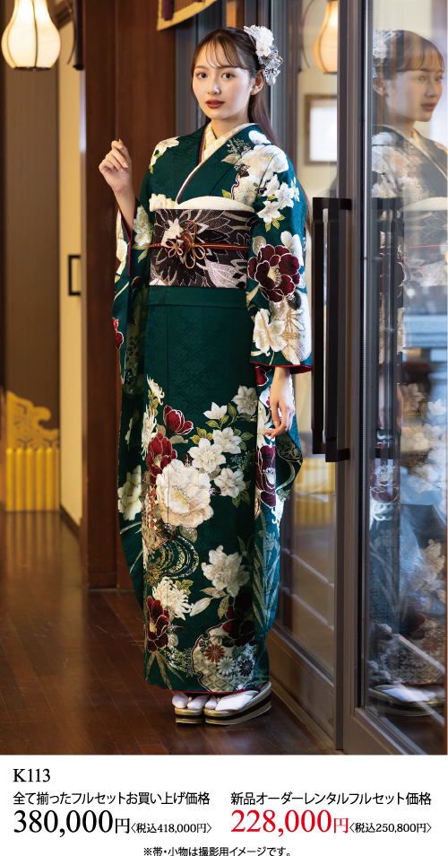 濃い緑色の花柄の着物に幅広の帯を締めた若い女性が室内に立っている。白い花のヘアアクセサリーをつけている。画像の下に日本円での価格とレンタル情報が表示されています。.