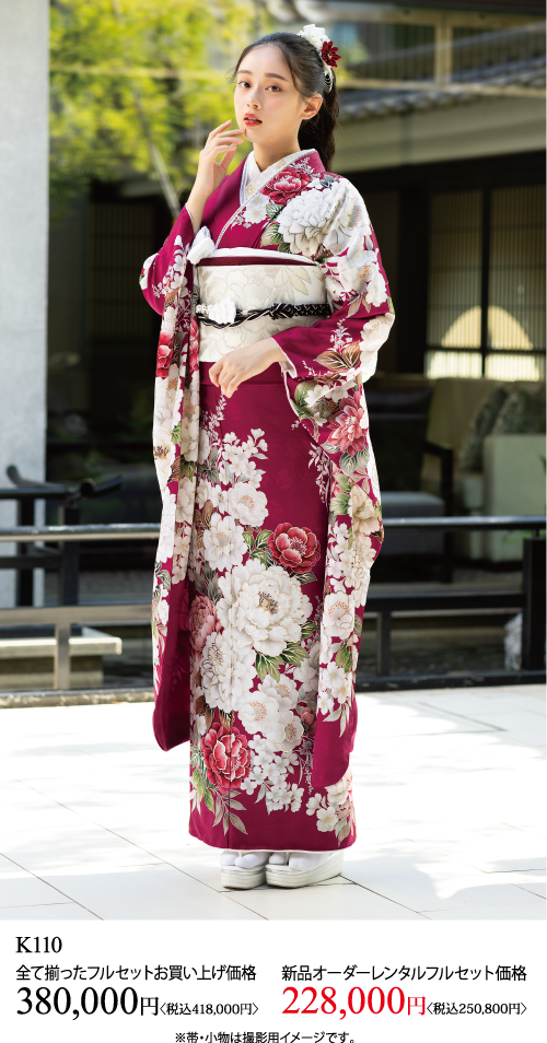 赤と白の花柄の着物を着た女性が屋外の石の上に立っている。着物の袖の一部を持ち、髪には白い花をつけている。画像の下に日本語のテキストと価格が表示されている。.