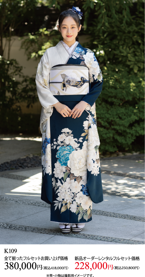 花模様の紺と白の着物を着て、飾り帯を締めた女性が屋外に立っている。下のテキストは、価格情報と商品コードを日本語で表示しています。.