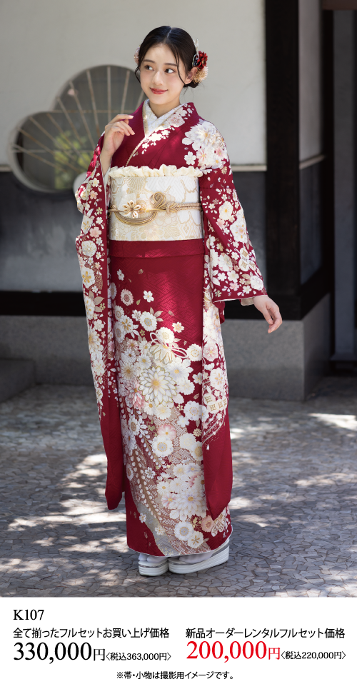 赤と白の花柄の着物に金の帯を締め、屋外に立っている若い女性。横を向いて微かに微笑んでいる。画像の下部には日本語のテキストと価格が表示されている。.