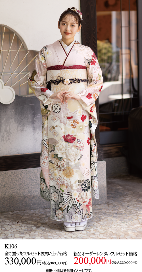 伝統的な淡い色の花柄の着物にピンクの帯を締めた若い女性が外に立っている。両手を前で合わせて微笑んでいる。着物購入とレンタルのための日本語テキストと料金の詳細は下部に表示されている。.