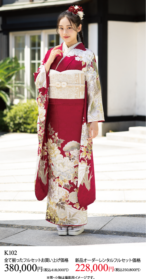 赤と白の花柄の着物に白い帯を締めた若い女性が外に立っている。花柄の髪飾りをつけ、微かに微笑んでいる。下部に日本語のテキストと着物のレンタル料金が表示されている。.