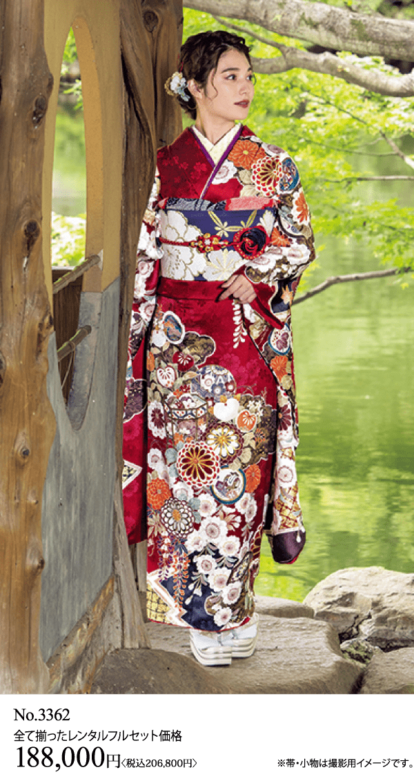 赤と白の花柄の着物を着た女性が、緑と水を背景に、池のほとりの小さな木造建築の入り口に立っている。価格とレンタルセットの情報は下部に日本語で表示されている。.