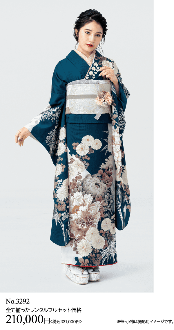 濃い茶色の花柄の着物に銀の帯、白い草履を履いて立つ女性。明るい背景の中でポーズをとっている。画像の下には、レンタル料金の詳細が日本語と日本円で書かれている。.