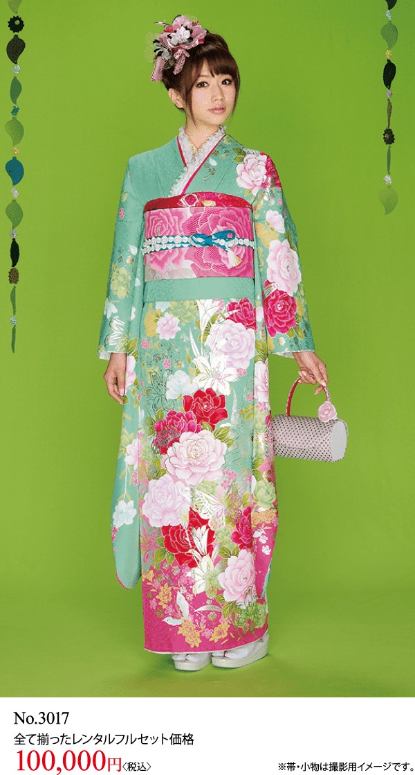 ターコイズブルーとピンクの花柄の着物を着て、ピンクの帯と髪飾りをつけた女性が緑色の背景の前に立っている。小さな白いハンドバッグを持っている。下のテキストにはレンタル料金が10万円と記載されている。.