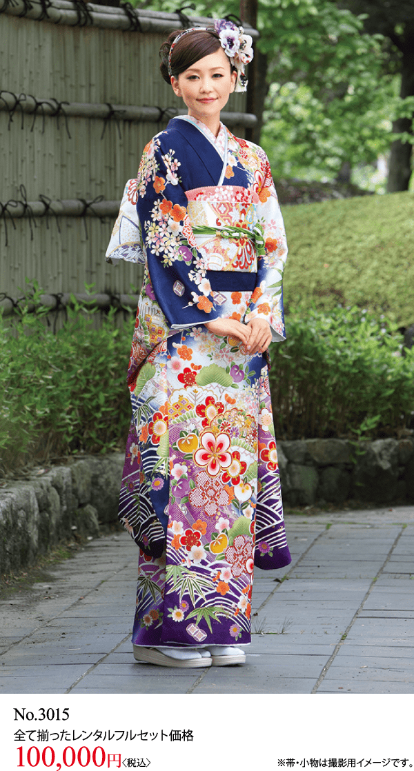 色とりどりの花柄の着物を着た女性が、屋外の石畳の道に立っている。花のヘアアクセサリーをつけ、微かに微笑んでいる。下の文字にはNo.3015とレンタル料金10万円が表示されている。.