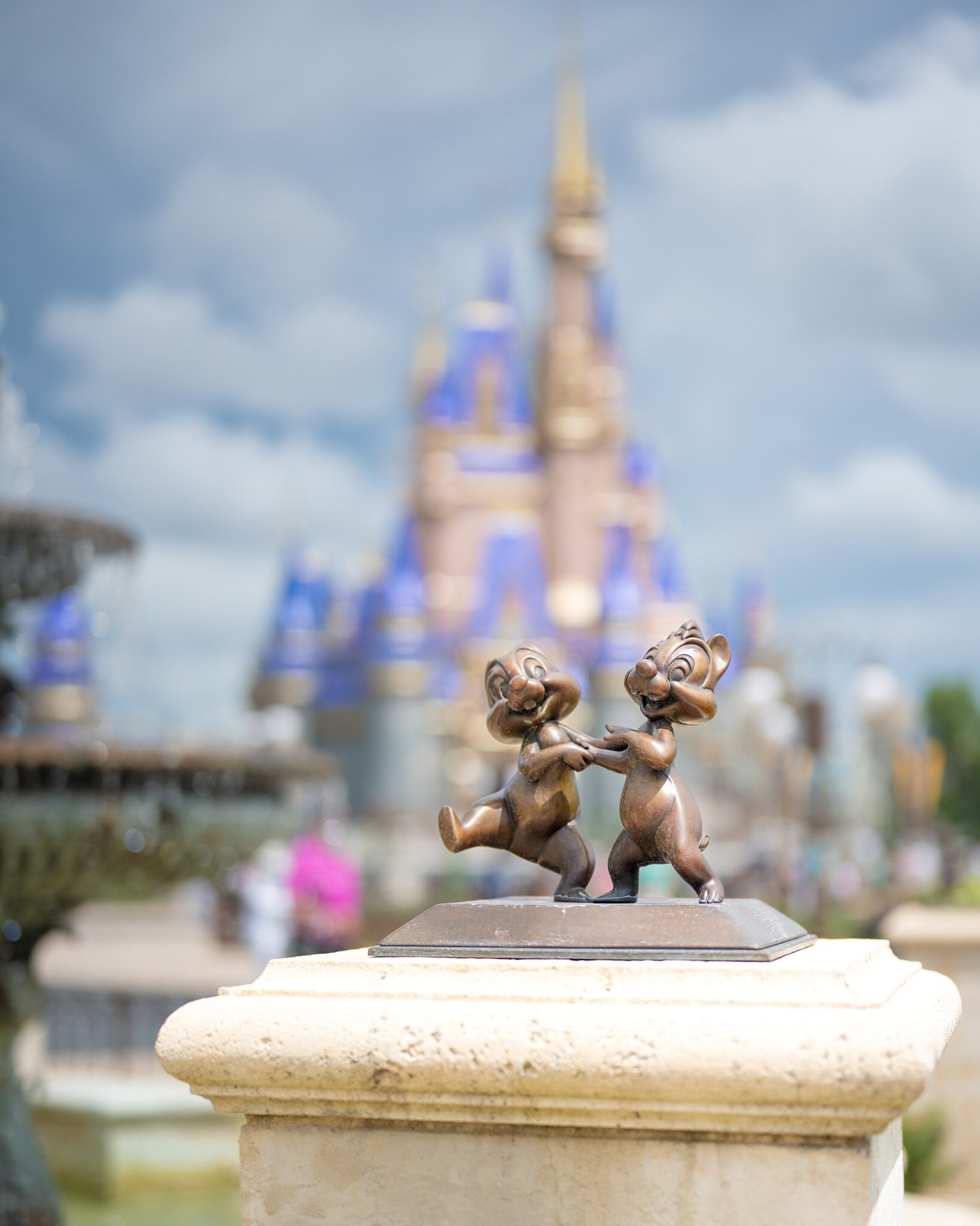 Estatua de Chip y Dale en Magic Kingdom con el Castillo de Cenicienta al fondo.