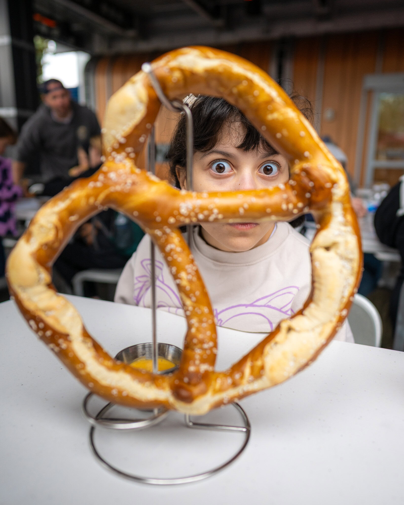 Daniela looking through a giant pretzel at Pym Test Kitchen in Avengers Campus.