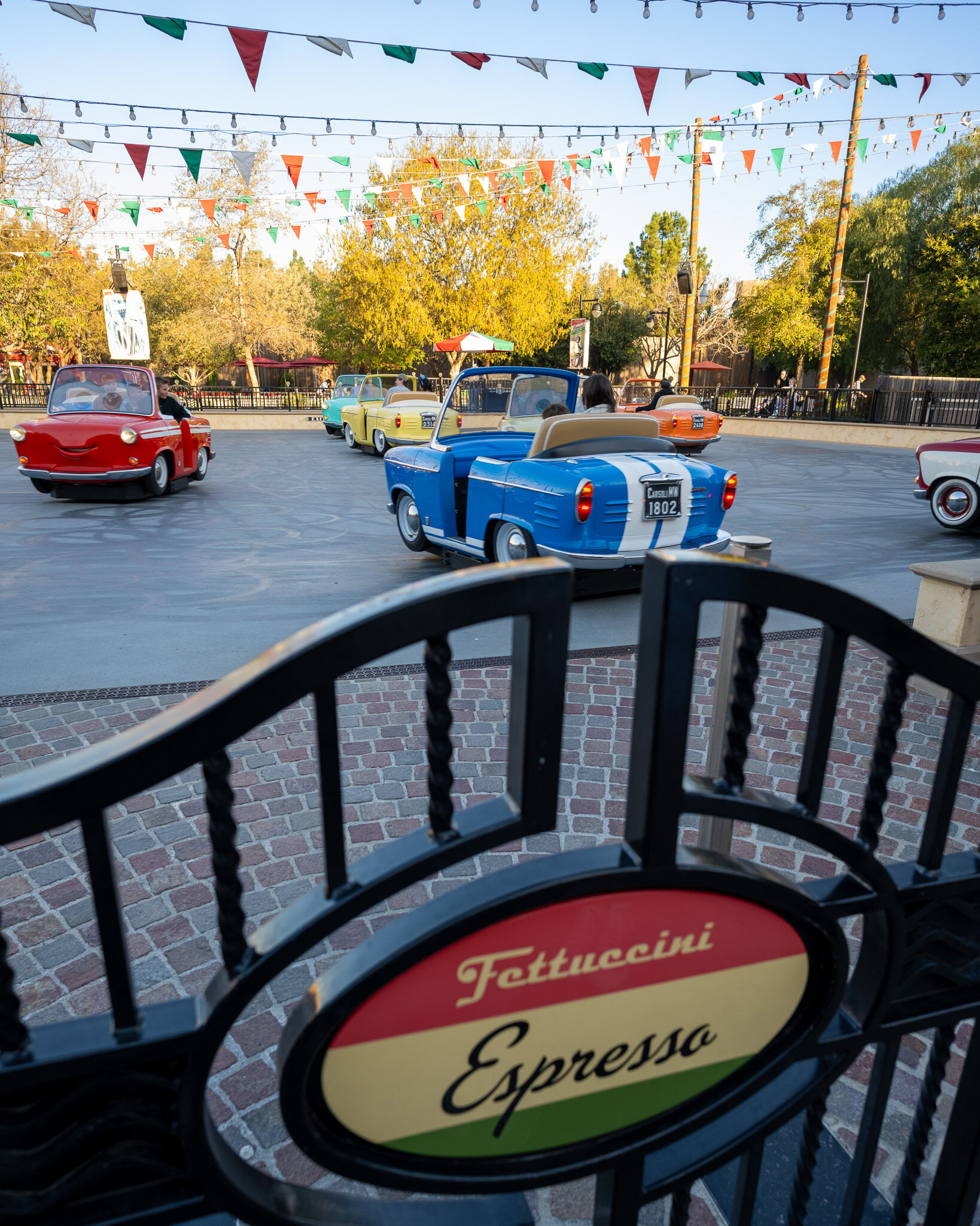 Guests riding Luigi’s Rollickin’ Roadsters viewed from the entry gate.