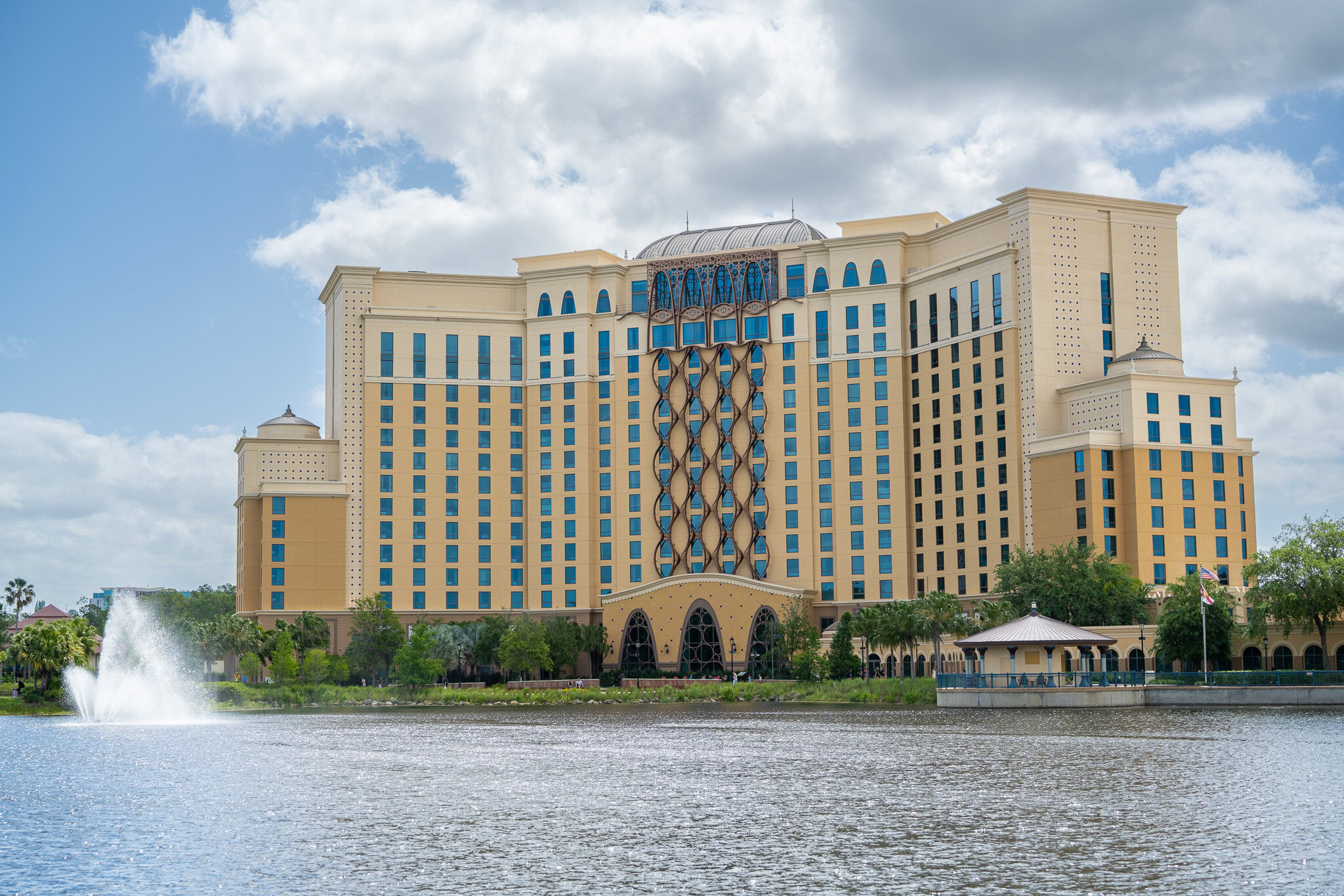 Daytime view of Disney’s Gran Destino Tower with lake and fountain in front