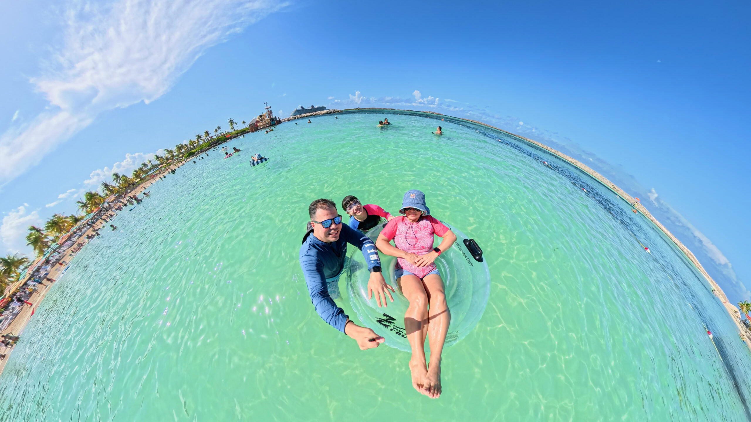 Family floating in the clear waters of Castaway Cay during a Disney Cruise Line beach day