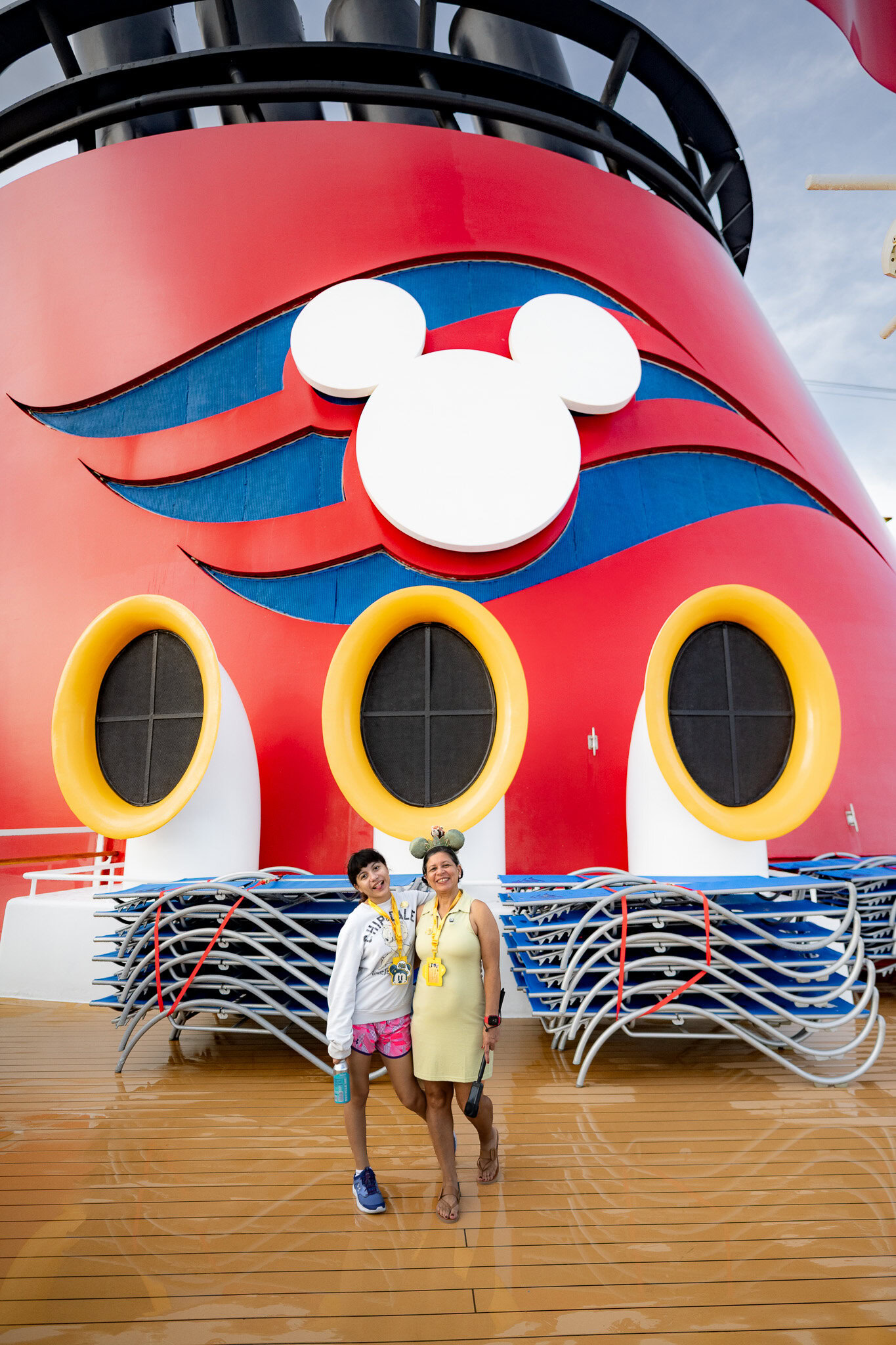 Lucy and Daniela posing in front of the Disney Magic funnel during embarkation day from San Juan Puerto Rico.