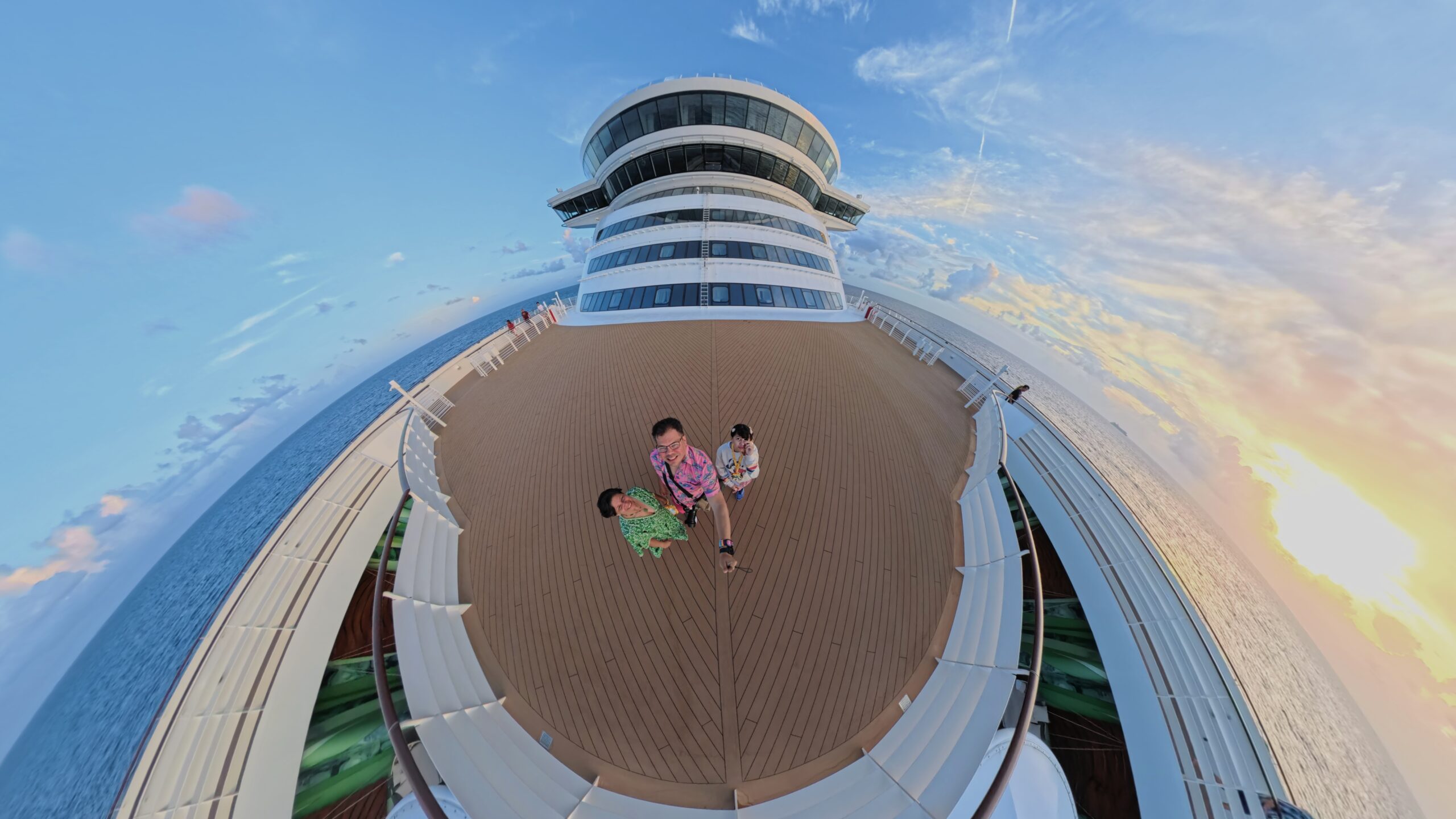 Family walking on the top deck of the Disney Wish at sunset during Nassau port day