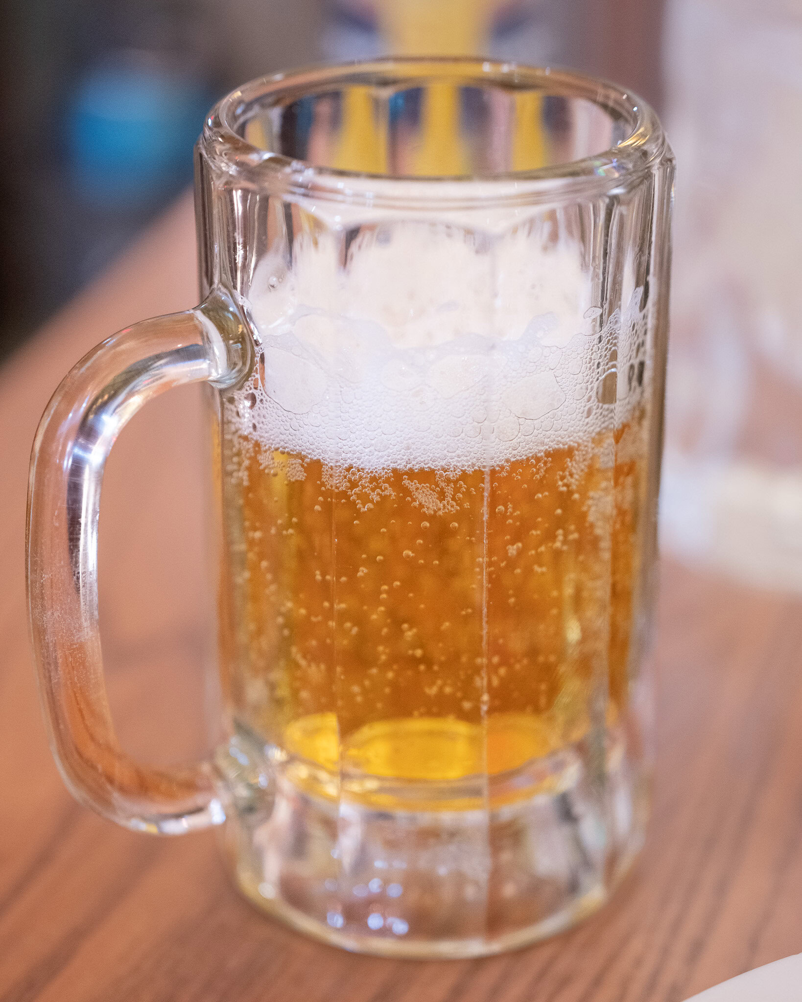 Cold beer in a glass mug on wooden table at Via Napoli