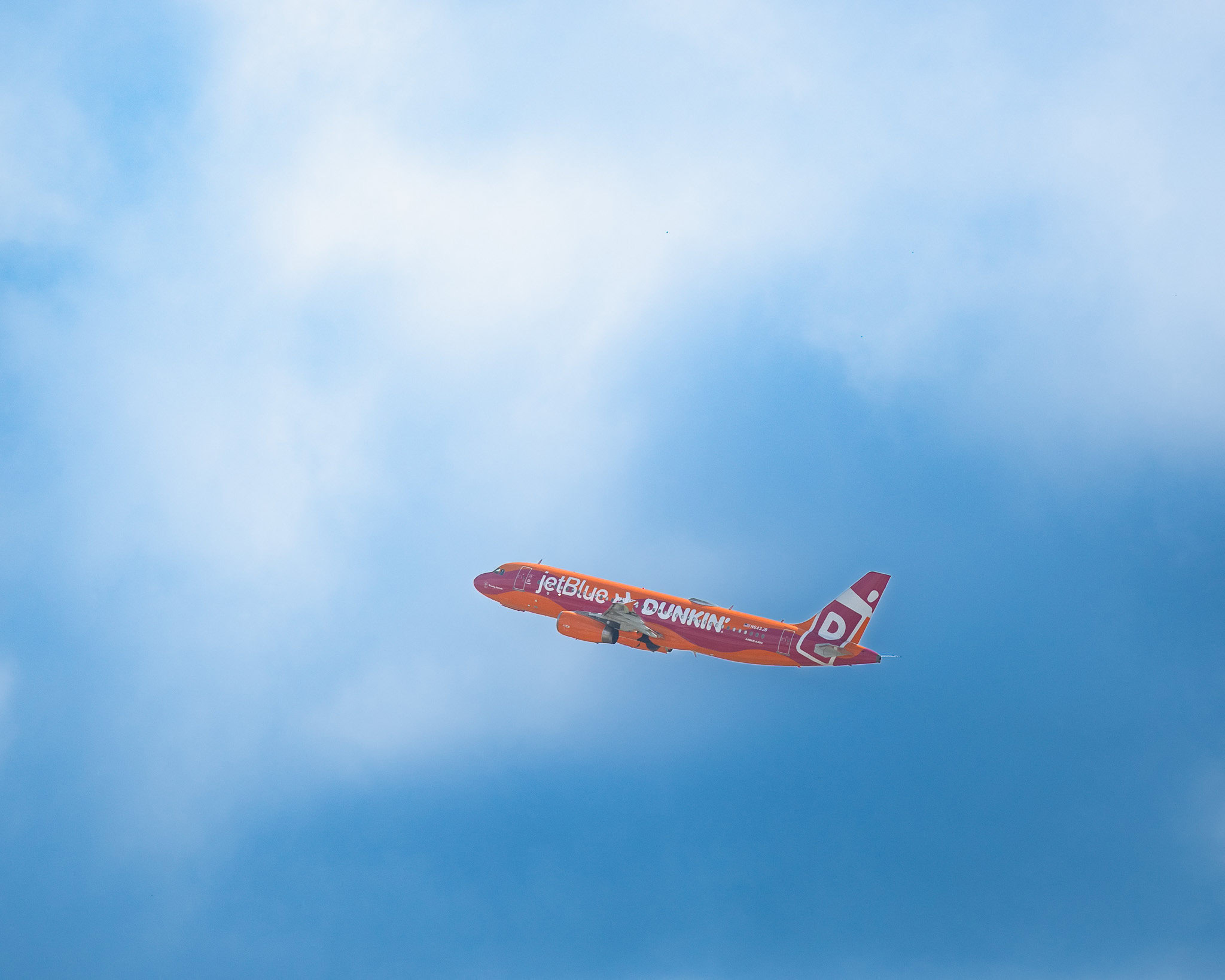 JetBlue airplane with Dunkin' Donuts livery flying over Orlando