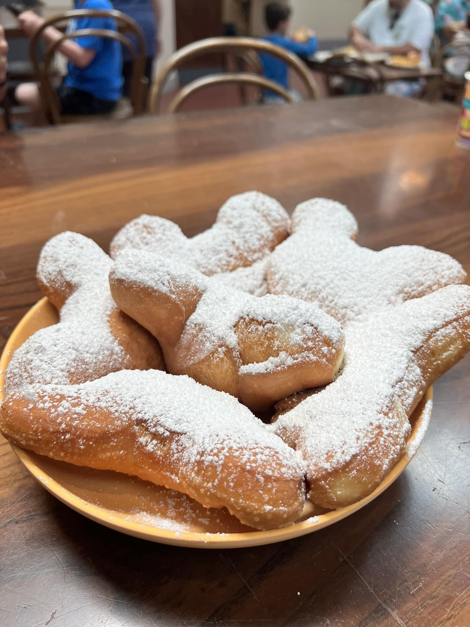 Un plato de buñuelos esponjosos en forma de Mickey espolvoreados con azúcar en polvo en Disney's Port Orleans Resort.