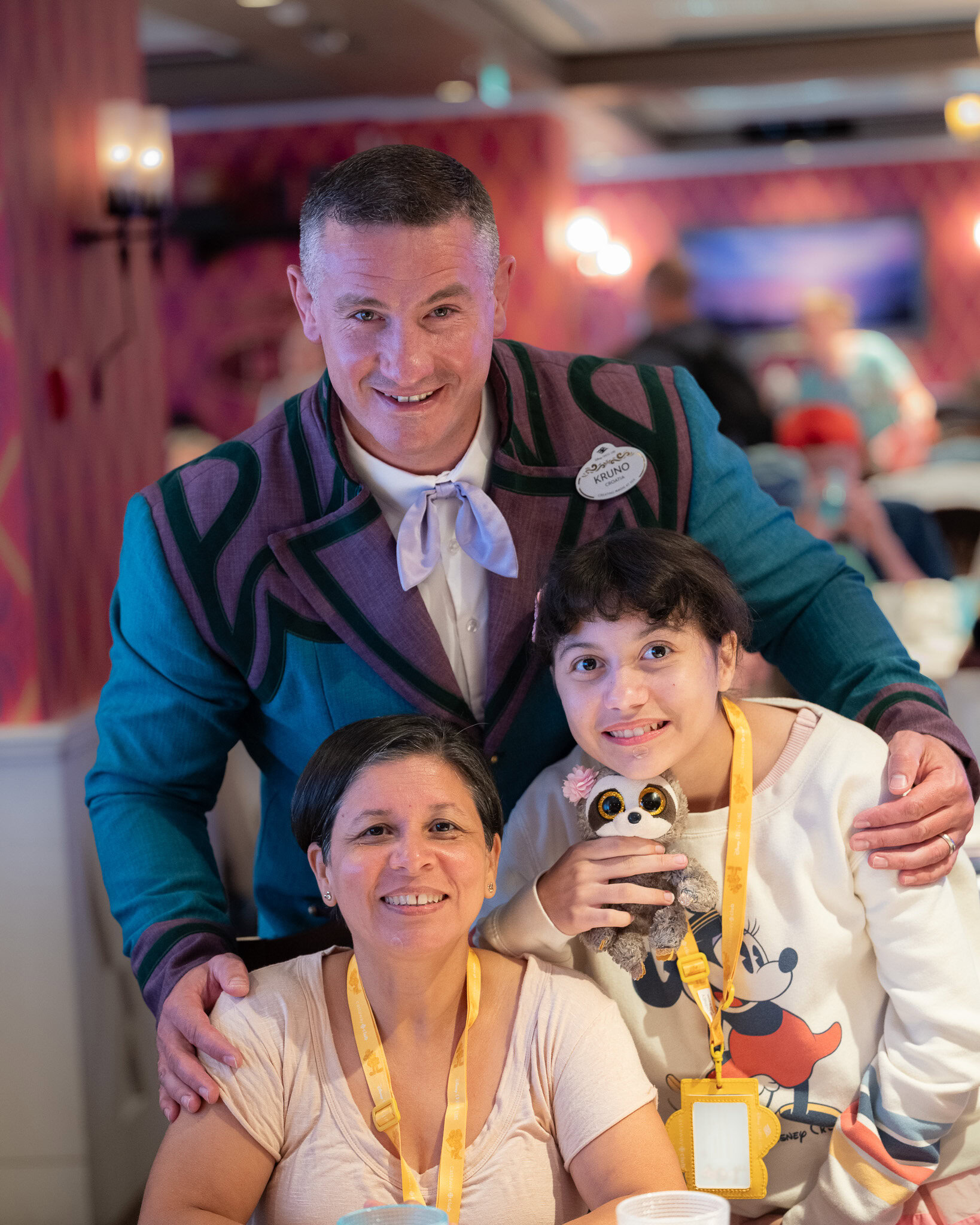 Disney Wish Arendelle Frozen Dinner server posing with family during dinner service.