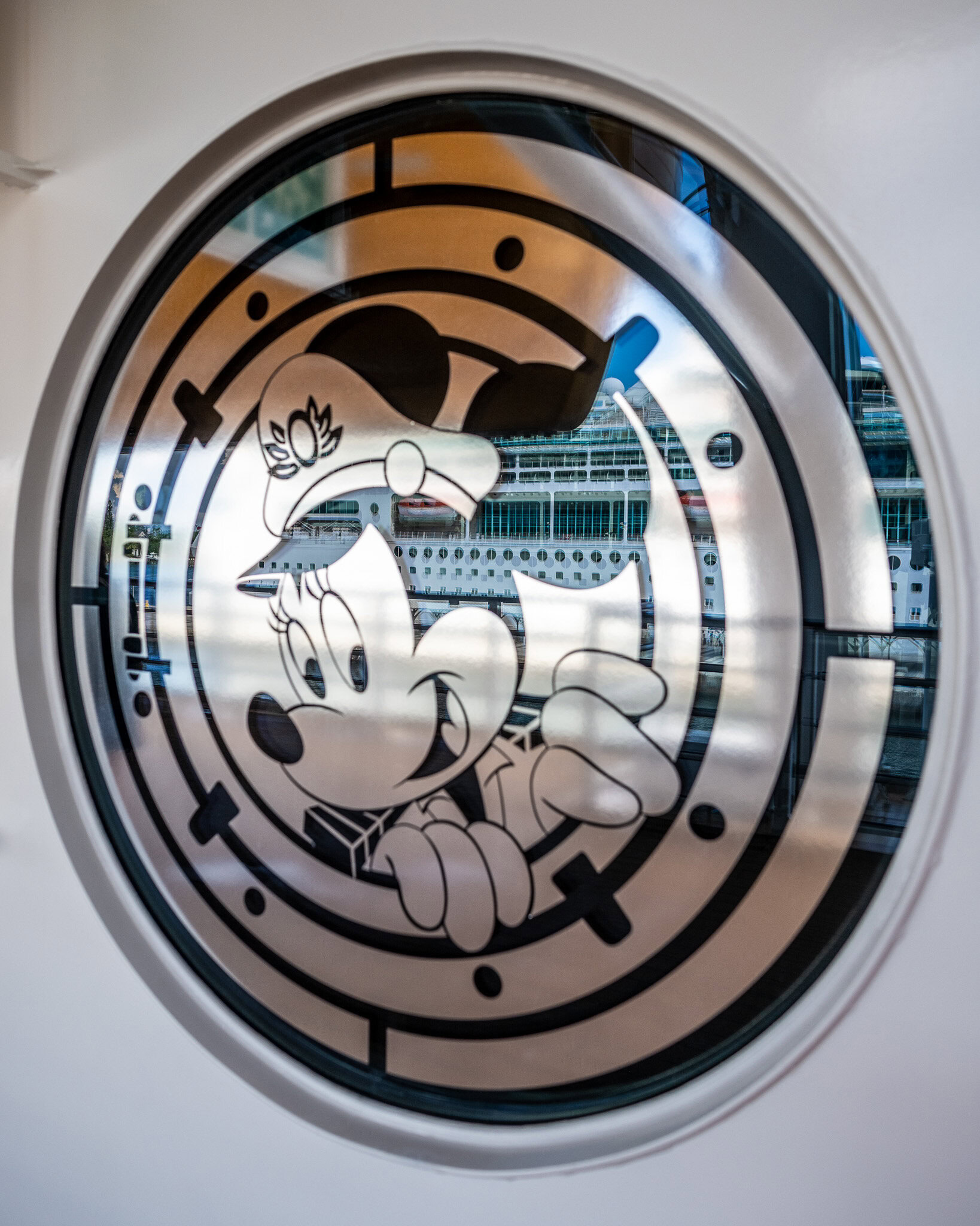 Window art of Minnie Mouse with reflection of another cruise ship